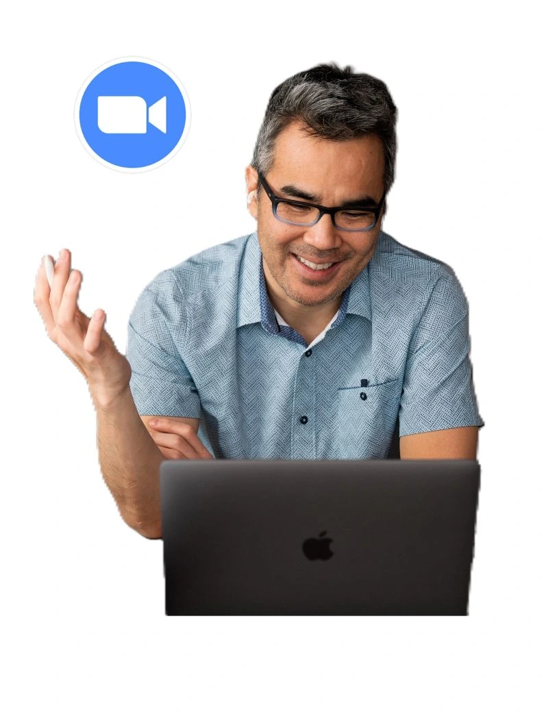 Luis sitting at a computer, engaged in a virtual meeting. He is in a well-lit workspace with a professional and collaborative atmosphere.